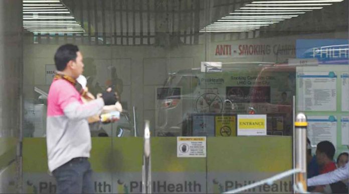 A delivery rider walks in front of the Philippine Health Insurance Corp. (PhilHealth) office. President Ferdinand Marcos Jr. instructs PhilHealth to defer the contribution hike this year based on the current economic conditions. ABS-CBN NEWS PHOTO