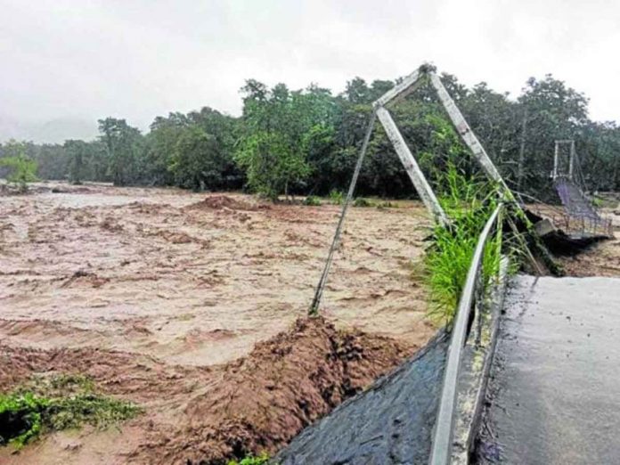 A massive flood triggered by a low pressure area and the northeast monsoon rages through Brooke’s Point, Palawan, causing the Cabinbin hanging bridge in Barangay Imulnod to collapse on Tuesday due to the strong current. CONTRIBUTED PHOTO