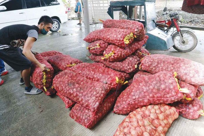 Sacks full of onions are unloaded at a Kadiwa market in Barangay Tumana, Marikina City. The Department of Agriculture is eyeing the importation of 22,000 metric tons of onions, adding that it must arrive before the peak harvest that will start in March. PNA PHOTO BY JOEY O. RAZON