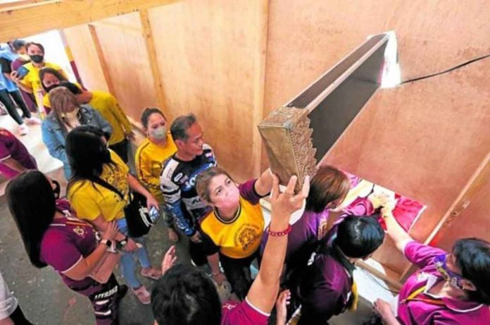 TOUCH AND GO. Devotees of the Black Nazarene troop to Quirino Grandstand in Manila on Monday to touch the feet of the image of Jesus Christ and a part of the cross as the traditional kissing (“pahalik”) of the image has been disallowed amid the pandemic. NIÑO JESUS ORBETA, PHILIPPINE DAILY INQUIRER