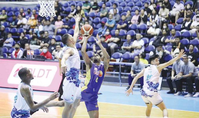 TNT Tropang Giga’s Jalen Hudson is forced to a tough shot by the defense of Phoenix Super LPG Fuel Masters’ Simon Camacho. PBA PHOTO