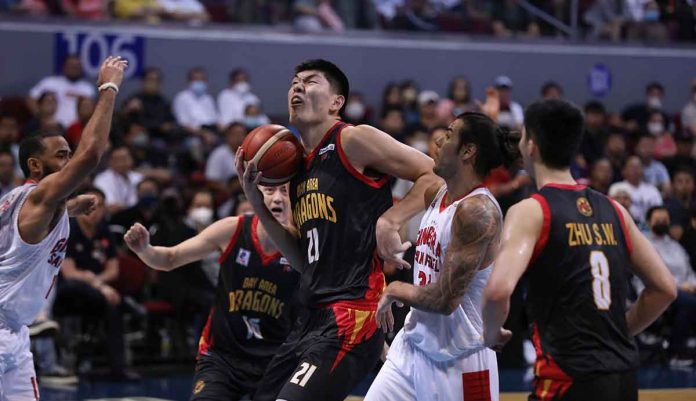 Bay Area Dragons’ Liu Chuanxing wards off the defense of Barangay Ginebra San Miguel Kings’ Christian Standhardinger for an inside attempt.PBA PHOTO