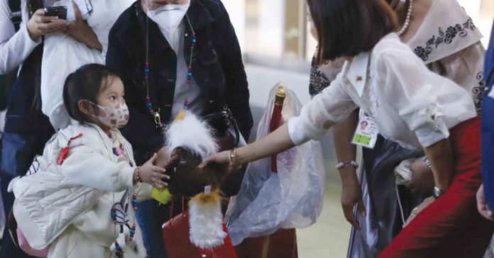 Tourism secretary Cristina Frasco welcomes Chinese visitors from Xiamen at the NAIA Terminal 1 on Tuesday, Jan. 24. PNA PHOTO BY JOEY RAZON