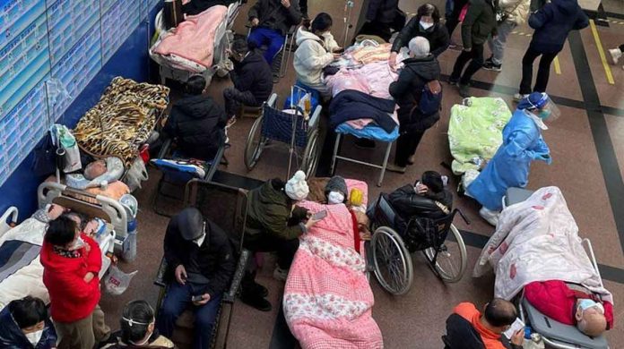 Patients lie on beds and stretchers in a hallway in the emergency department of a Shanghai hospital. REUTERS