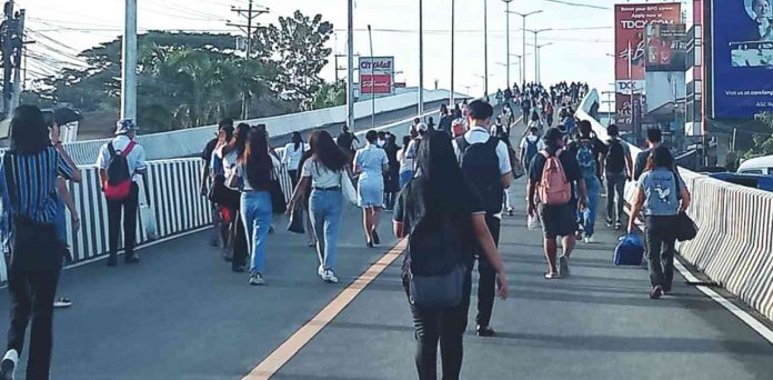 FLYOVER TURNS INTO OVERPASS. Traffic congestion has driven desperate commuters to forcibly open the closed half-a-kilometer-long Ungka flyover and walk through it. AJ PALCULLO/PN