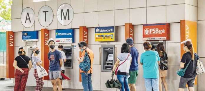 People are queuing to withdraw cash from automated teller machines. The World Bank said only 51 percent of Filipinos aged 15 and above are having a transaction account with a financial institution. AFD/EZRA ACAYAN PHOTO