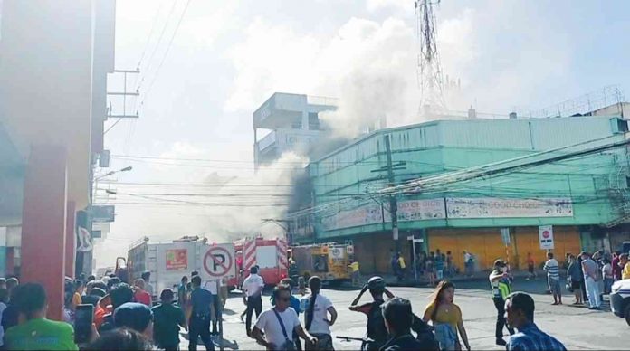 BUILDING ON FIRE. Thick smoke billows from this fire-hit three-storey commercial building in Barangay 37, Bacolod City on Sunday. Property damaged is pegged at over P20 million, according to the Bureau of Fire Protection. As of press time, the cause of the blaze remains unknown. MAE SINGUAY/PN