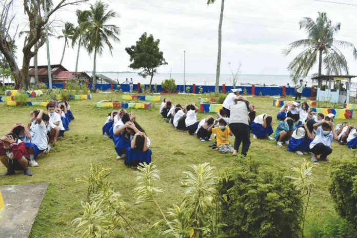 Students, teachers and faculty of Paaralan ng Buhay ng Tando in Nueva Valencia, Guimaras perform the "drop, cover, hold, clear, and out" scenario during the earthquake drill. PROVINCE OF GUIMARAS FACEBOOK PAGE