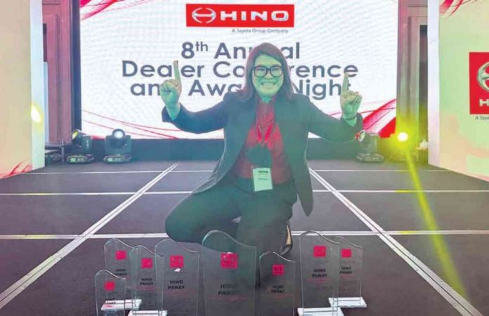 Hino-Panay's President, Gen Aguillon-Chiong, CPA with the Dealer of the Year Award and seven more trophies.