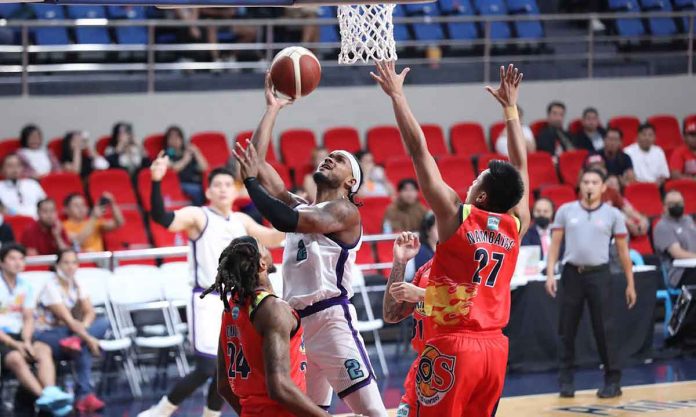 Converge FiberXers’ Abu Tratter splits the defense of Rain or Shine Elasto Painters’ Michael Qualls and Rey Nambatac for an inside hit. PBA PHOTO