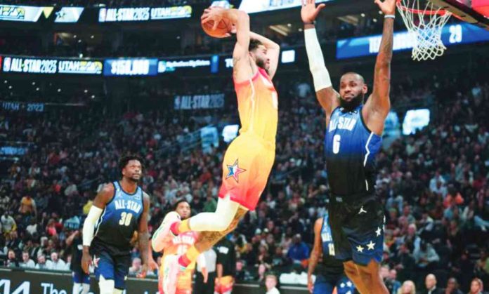 Jayson Tatum of Team Giannis goes for a two-handed dunk as LeBron James of Team LeBron turns his back. AP