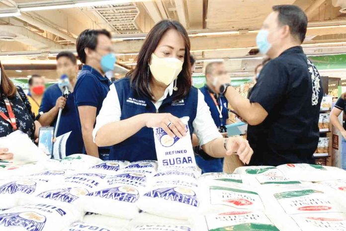 Department of Trade and Industry personnel track prices of sugar in a supermarket in Manila. High prices of sugar were among the factors that pushed inflation up in the later months of 2022. DTI PHOTO