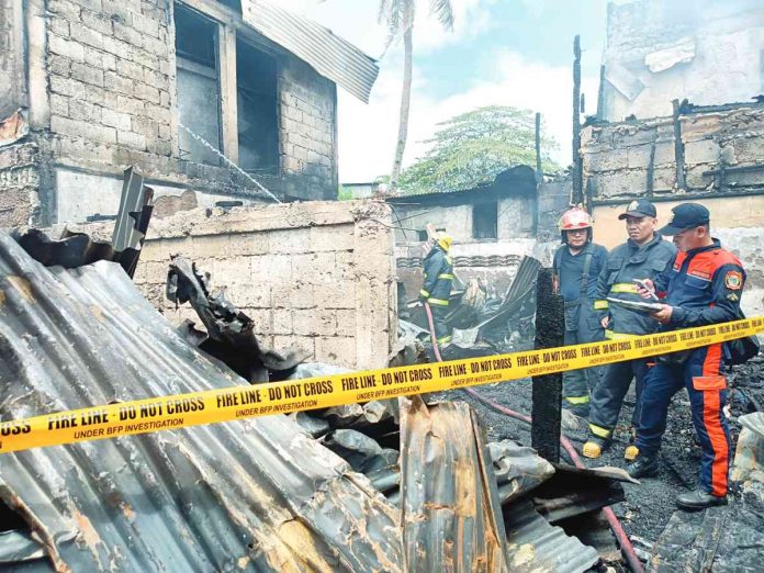 Bureau of Fire Protection personnel conduct a clearing operation after a fire hit a residential area in Barangay Jalandoni Estate, Lapuz, Iloilo City on Friday, March 17. Twenty houses were gutted. AJ PALCULLO