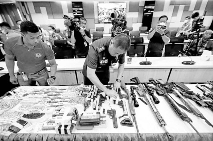 FIREPOWER. Personnel of the Criminal Investigation and Detection Group check the firearms and bullets seized during a raid on the property of former Negros Oriental Gov. Pryde Henry Teves, younger brother of suspended Rep. Arnolfo Teves Jr., before these are presented at a news briefing on Monday, March 27, 2023. PHOTO BY GRIG C.MONTEGRANDE / PHILIPPINE DAILY INQUIRER