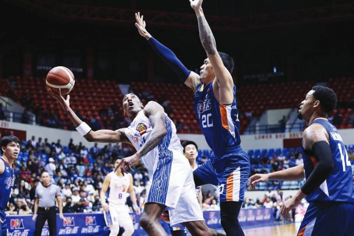 TNT Tropang Giga’s Rondae Hollis-Jefferson is forced to a tough shot by the defense of Meralco Bolts’ Raymond Almazan. PBA PHOTO