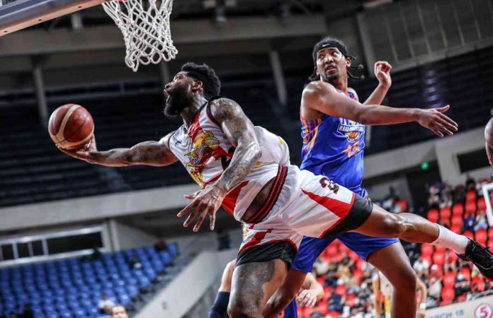 San Miguel Beermen’s Cameron Clark goes for a tough reverse basket as he evades the defense of NLEX Road Warriors’ Brandon Ganuelas-Rosser. PBA PHOTO