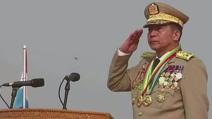 General Min Aung Hlaing stands at a podium and salutes. MYAWADY MEDIA PHOTO