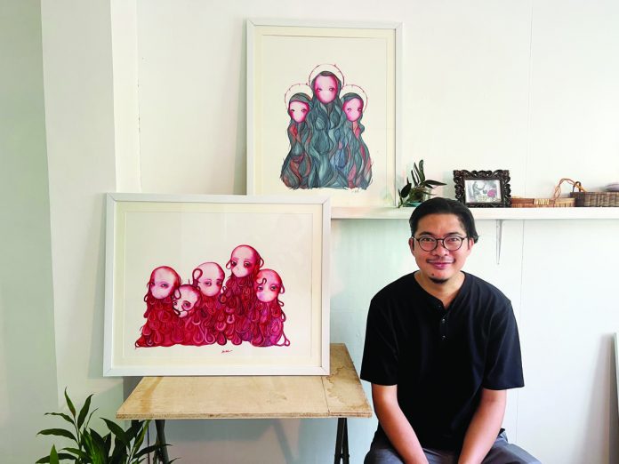 Painter Julius Redillas, first artist-in-residence of Istaran, with two of his watercolors (now in private collections) produced during his two-month residency in KANTINA, Roxas City.