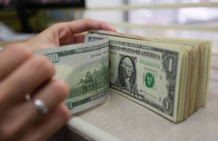 A store clerk counts their US dollar bills inside a money changer stall in Manila. The Philippine peso fell to a new record low for the fourth straight day on Wednesday, April 5, closing at P58.50 against the US dollar. GEORGE CALVELO/ABS-CBN NEWS PHOTO