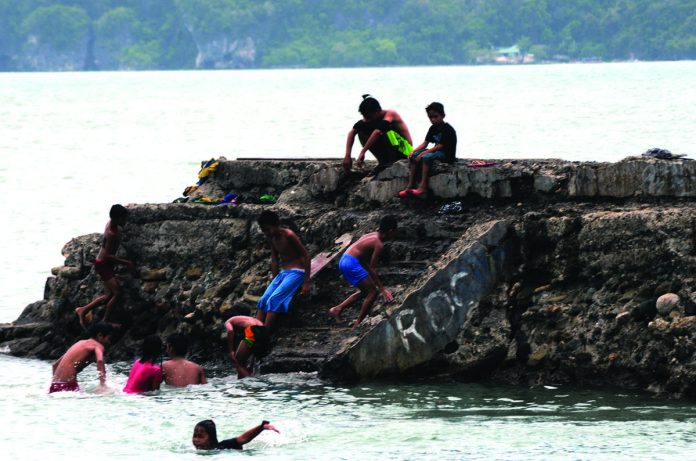 COOLING IT OFF. It’s summer. It’s hot. And there’s a blackout. What should youngsters do? For these young residents of Iloilo City, it’s time for a dip in the cool waters of the Iloilo Strait. They are shown here having fun at the breakwater of Fort San Pedro. PN PHOTO