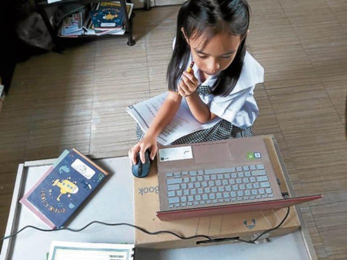 At home in Calamba, Laguna, a child wears a school uniform as she attends her second grade online class conducted a private school in Makati. FILE PHOTO BY CHRIS QUINTANA / INQUIRER SOUTHERN LUZON