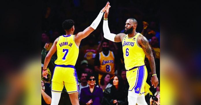 LeBron James (right) and Troy Brown Jr. give each other a high five. The Lakers is now one win away from upsetting the No. 2 seed Memphis Grizzlies in the Western Conference. GARY A. VASQUEZ/USA TODAY