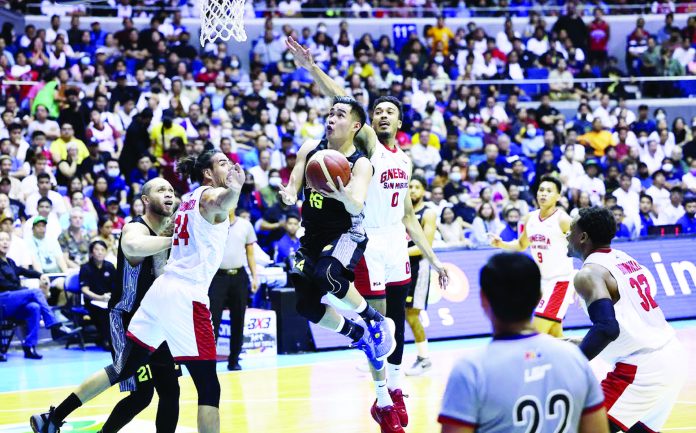 Bacolodnon Kib Montalbo of TNT Tropang Giga evades the defense of Barangay Ginebra San Miguel Kings’ Christian Standhardinger and Jeremiah Gray for a tough basket. PBA PHOTO