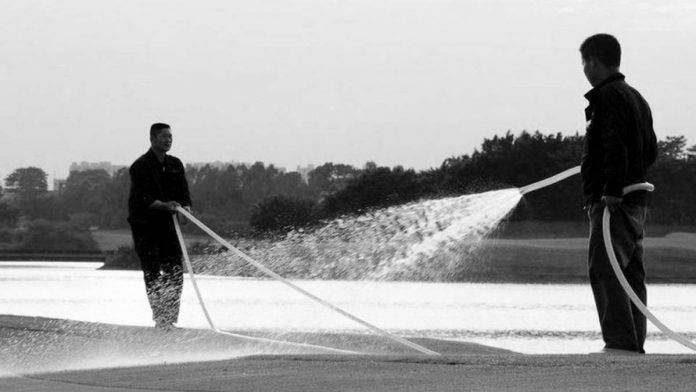 Men water a golf course. According to the United Nations, water scarcity is becoming endemic because of overconsumption and pollution, while global warming will increase seasonal water shortages in both areas with abundant water and those already strained. GETTY IMAGES