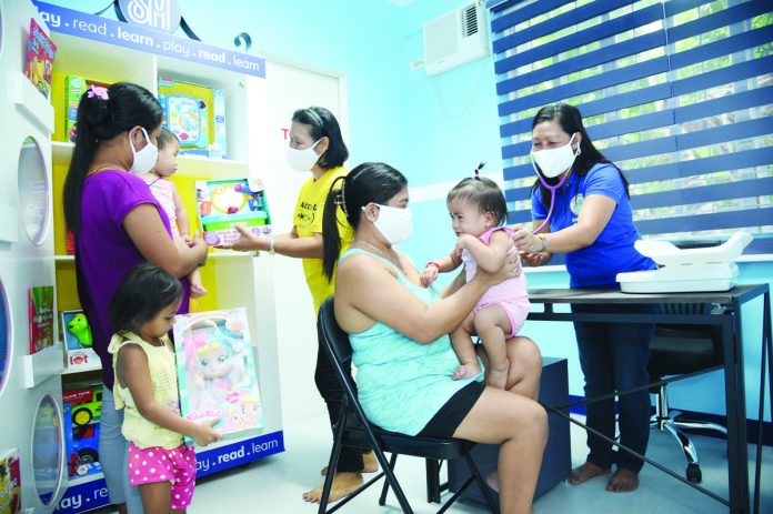 Community members enjoy free medical check-ups inside the child-friendly local health center refurbished by SM Foundation Inc.