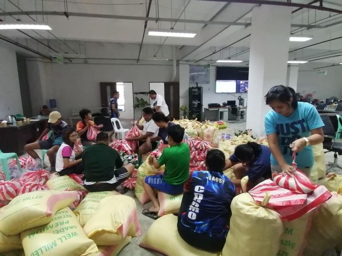 Personnel of the Passi City Disaster Risk Reduction and Management Council, members of the Kabataan Kontra Droga at Terorismo-Passi City Chapter and volunteers prepare for the distribution of relief goods to flood-hit families. PASSI CDRRMO PHOTO