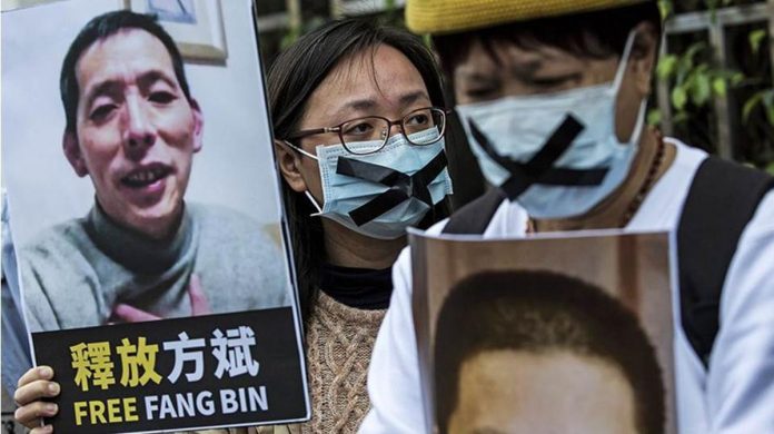 An activist holds a placard of missing citizen journalist Fang Bin, as she protests outside the Chinese liaison office in Hong Kong in 2020. AFP