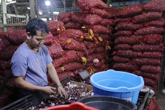 A vendor arranges the red onions at a stall inside the Balintawak Market in Quezon City. The Department of Agriculture will consider importing onions for price stability purposes. PNA PHOTO BY JOEY O. RAZON