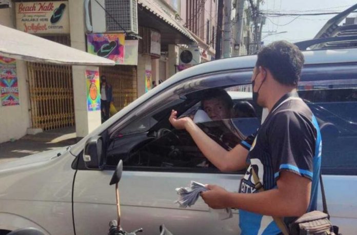 A traffic enforcer hands out a flyer about the paid parking ordinance of Iloilo City. The city government starts collecting parking fees from owners of parked vehicles on Monday, May 15. CITY GOV’T OF ILOILO FB PHOTO