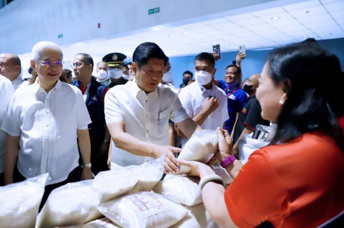 President Ferdinand R. Marcos Jr. inspects packed rice for sale at a “Kadiwa ng Pangulo Para Sa Manggagawa” outlet in Pasay City, with Department of Trade and Industry Secretary Alfredo Pascual (left). The President has vowed to make rice more affordable. PNA