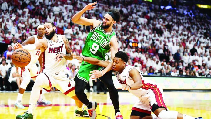 Derrick White of the Boston Celtics is being flanked by Miami Heat players. AP