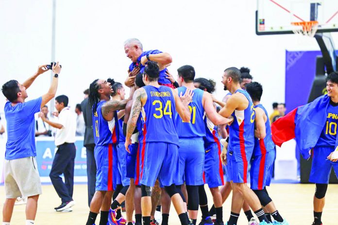 Gilas Pilipinas head coach Vincent “Chot” Reyes celebrates with his players after capturing the gold medal in the 32nd Southeast Asian Games. PSC PHOTO