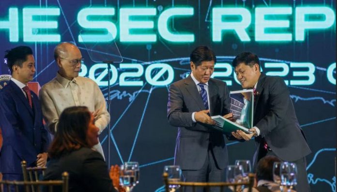 President Ferdinand Marcos Jr. receives a copy of “The SEC Reports,” which shows the programs and initiatives of the Securities and Exchange Commission (SEC), from SEC chairman Atty. Emilio Aquino (right) during the commission’s 85th Anniversary celebration in Makati City on Thursday, June 22. The agency is the registrar and overseer of the corporate sector in the country and supervises more than 600,000 active corporations registered with it. JONATHAN CELLONA/ABS-CBN NEWS PHOTO