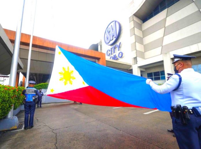 Security guards of SM City Iloilo get ready to raise the Philippine flag in front of the mall in line with the celebration of the 125th Philippine Independence Day on Monday, June 12.