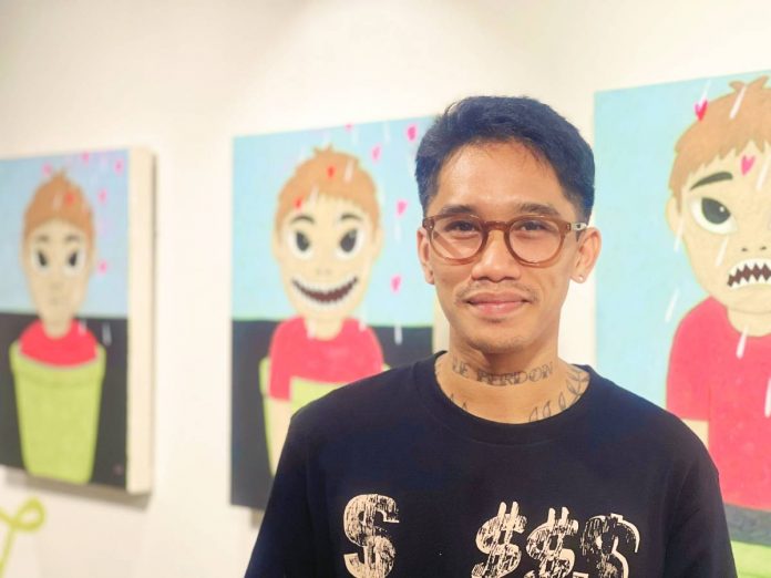 Artist Namo with his paintings at Mamusa Art Gallery during the opening of his solo exhibit “Just a Lover”