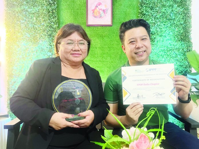 Program manager Mona Liza S. Diones (left) and chapter board president Atty. Jon Cerlan Bangoy celebrate Family Planning Organization of the Philippines - Iloilo’s top performance rating award for 2022.