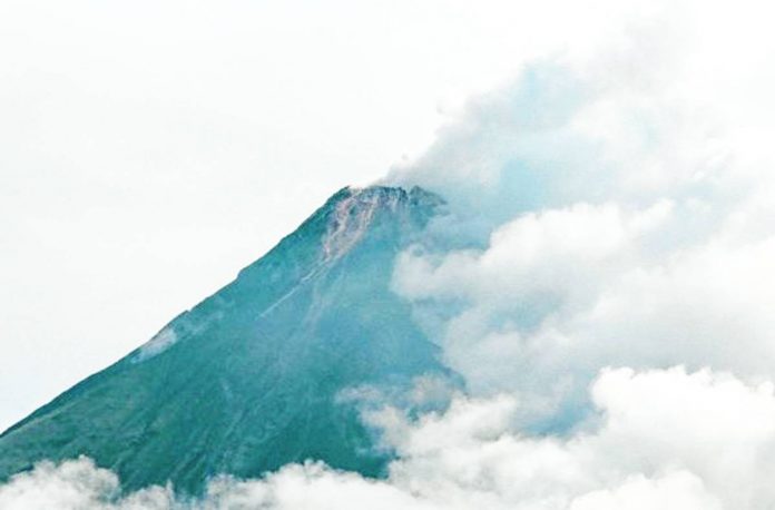 The summit of Mayon Volcano in Albay is partly covered with clouds in this photo taken on June 5, 2023. The Philippine Institute of Volcanolofgy and Seismology has raised Alert Level 3 Thursday morning due to increasing number of rockfalls. MARK ALVIC ESPLANA