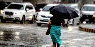 Armed with an umbrella, a pedestrian hurriedly crosses a street under heavy downpour in Kamuning, Quezon City. State weather bureau PAGASA declared the onset of the wet season but the expected El Niño by July or August will bring below-normal rainfall conditions and dry spells in some parts of the country. PNA