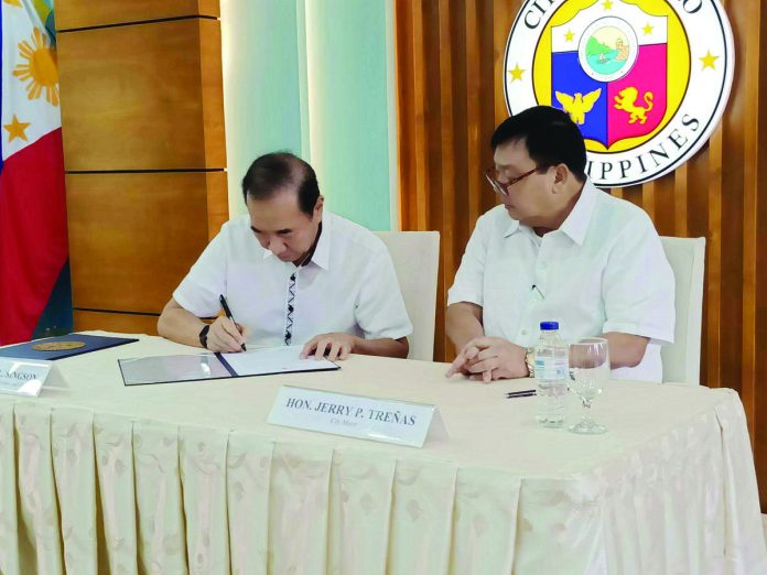 Mayor Jerry Treñas (right), representing the Iloilo City Government, and Metro Pacific Investment Corporation president and chief executive officer Rogelio "Babes" Singson (left) sign the certification relative to the successful negotiation for the construction of a state-of-the-art waste-to-energy facility in the metropolis.