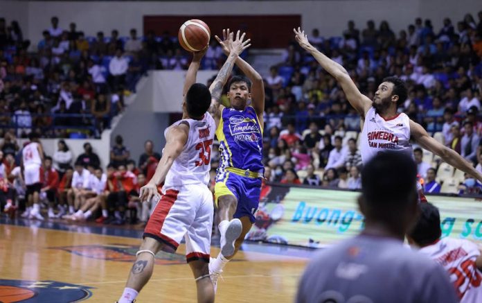 Magnolia Chicken Timplados Hotshots’ Andy Mark Barroca looks to pass the ball after being bothered by the defense of Barangay Ginebra San Miguel Kings’ Kim Aurin. PBA PHOTO