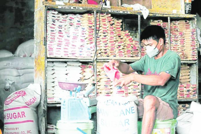 A store helper repacks sugar at a public market in Quezon City. NIÑO JESUS ORBETA/INQUIRER.NET PHOTO