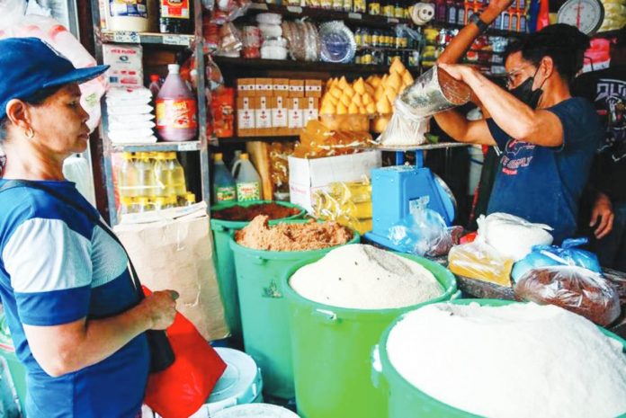 A store worker attends to a customer buying sugar at a stall in Bagong Silang public market in North Caloocan. JONATHAN CELLONA/ABS-CBN NEWS PHOTO