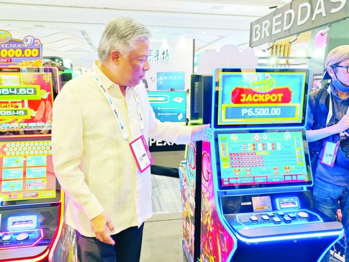 Philippine Amusement and Gaming Corporation chairman and CEO Alejandro Tengco inspects a modern slot machine which was exhibited at the SiGMA Asia Summit 2023 in Pasay City.