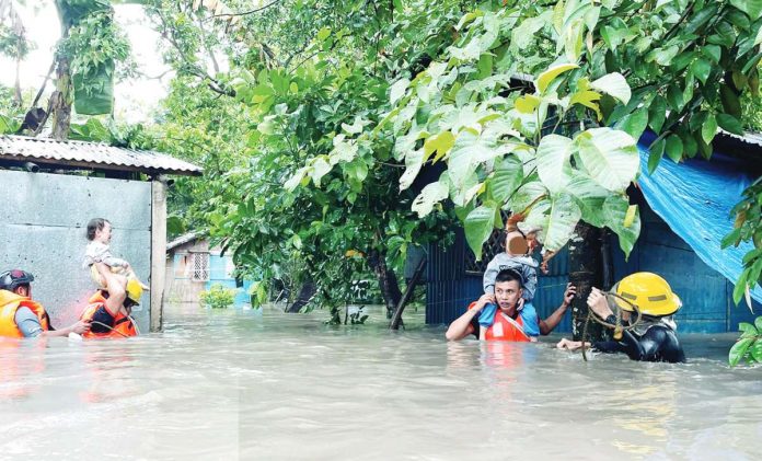 Personnel of the Bureau of Fire Protection rescue residents affected by flood in barangays Sum-ag, Pahanocoy and Singcang-Airport in Bacolod City on Tuesday, July 25. BFP-BACOLOD CITY FIRE STATION PHOTOS