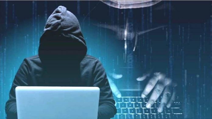 An illustration shows a scammer in a hoodie working on a computer. IMAGE BY DANNIE AGACER / INQUIRER.NET