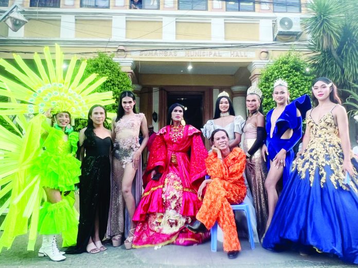 Dumangas cultural icon and historic first Grand Marshal Peter Solis Nery (seated) poses with colorful participants of the Dumangas Pride parade in front of the municipal hall.